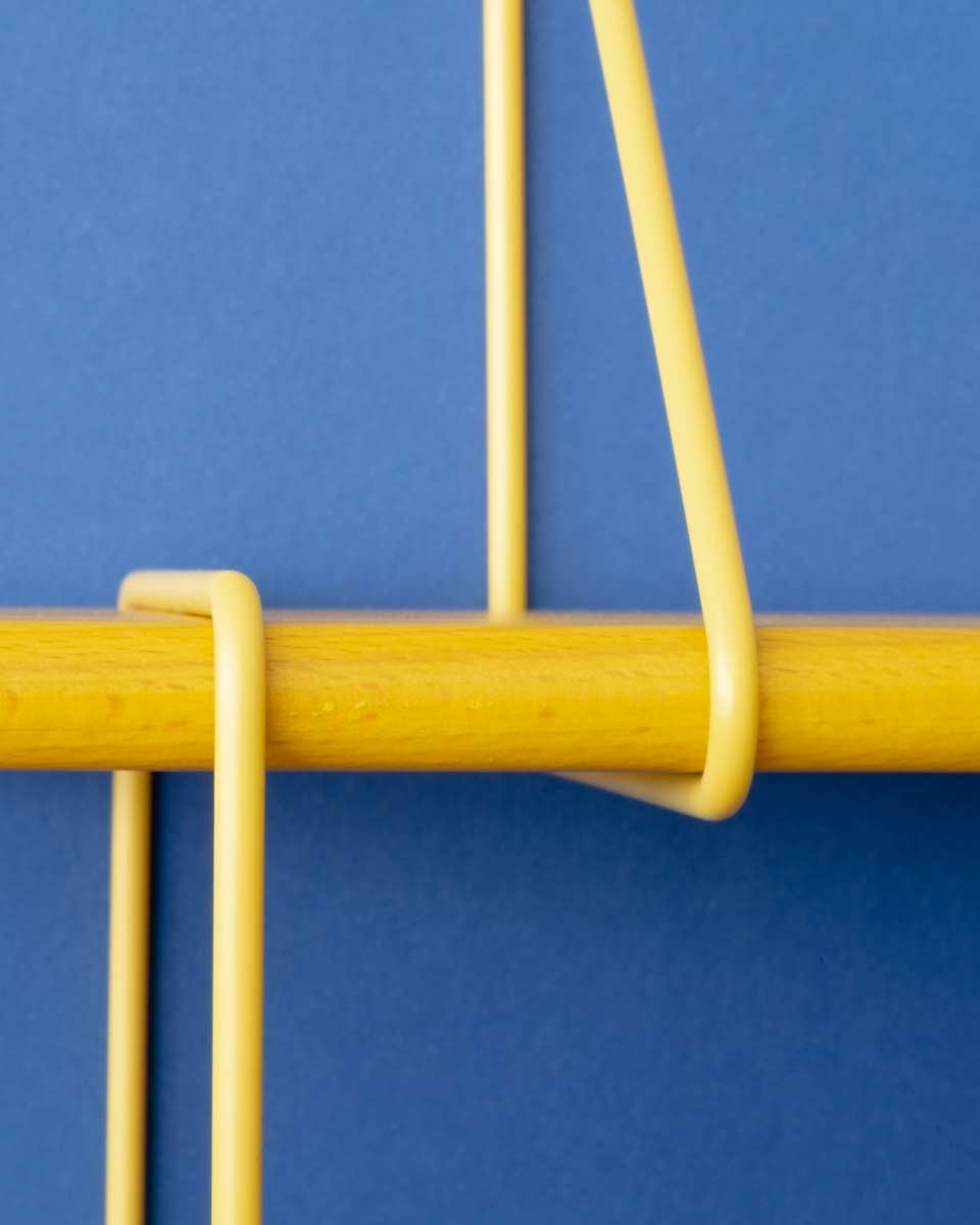 Dettaglio libreria gialla in metallo e legno di faggio